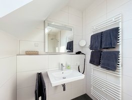 Badezimmer im Ostsee-Domizil Ferienhaus Hohwacht mit Waschtisch, Handtüchern & Fön