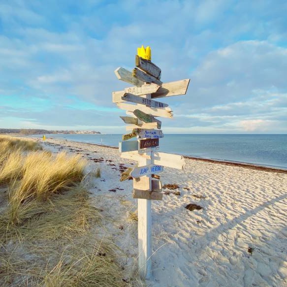 Hölzerner Wegweiser am Strand von Hohwacht