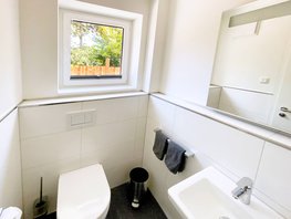 Gäste-WC im Ostsee-Domizil Ferienhaus Hohwacht mit Waschtisch, Spiegel und Toilette