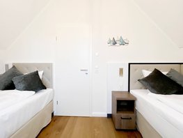 Schlafzimmer mit zwei Einzelbetten links & rechts, mit Nachtschrank im Ostsee-Domizil Ferienhaus Hohwacht