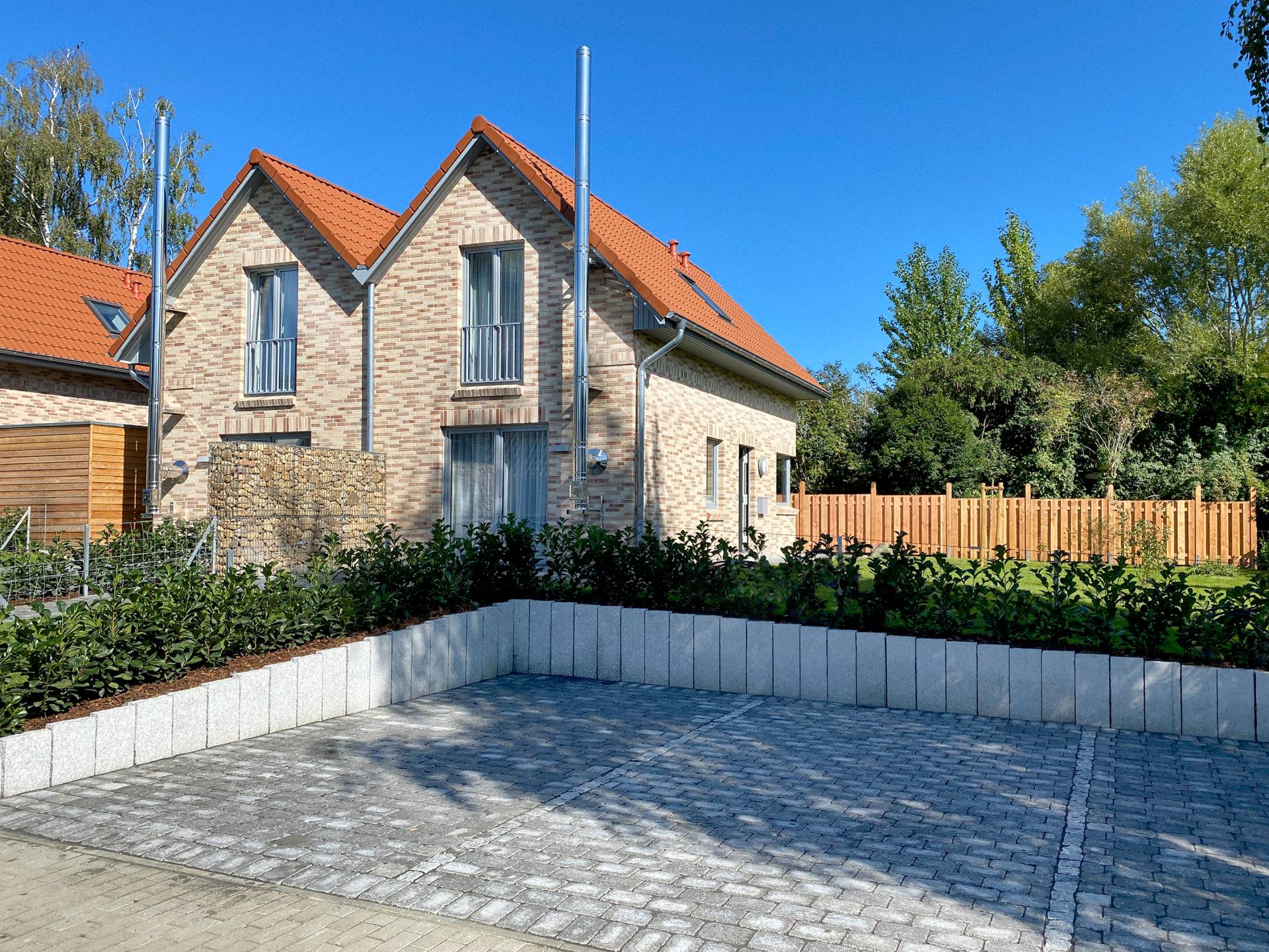 Außenansicht Doppelhaushälfte mit Parkplätzen | Ferienhaus Ostsee-Domizil Außenansicht einer Doppelhaushälfte mit Parkplätzen des Ferienhauses Ostsee-Domizil in Hohwacht