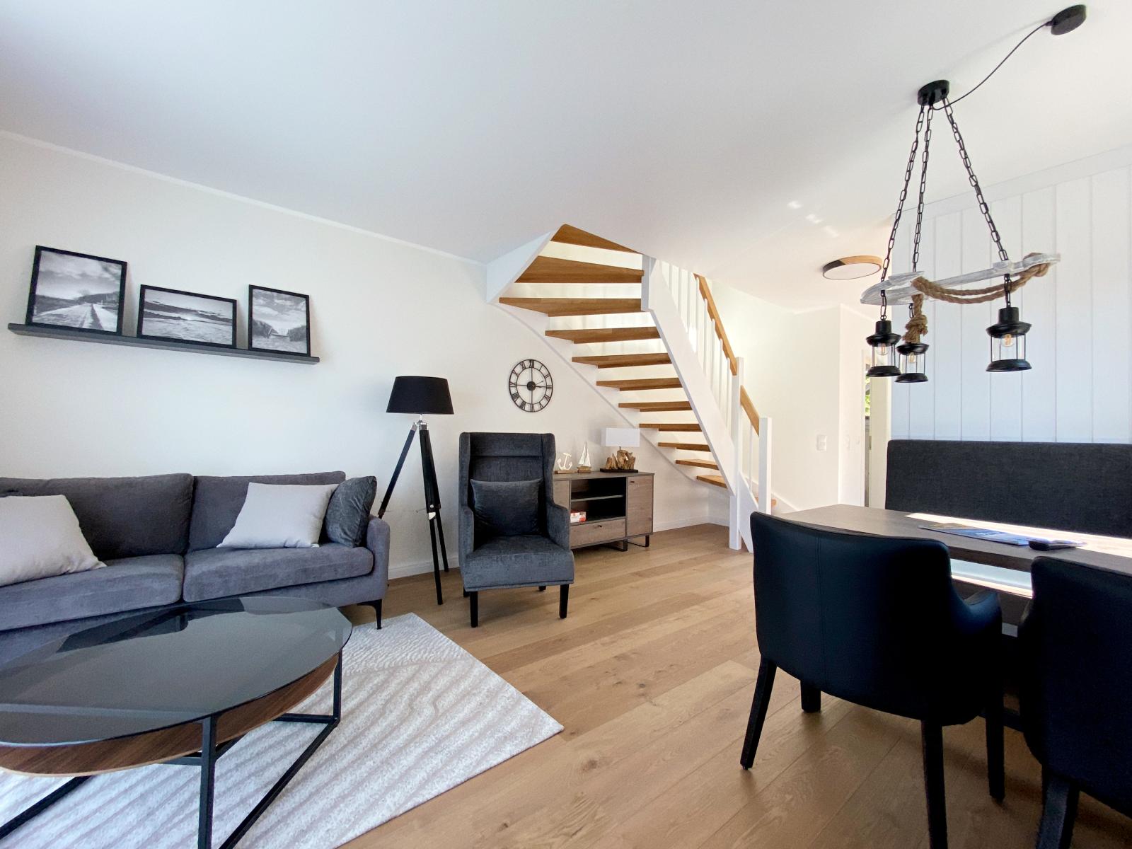 Wohn- & Essbereich mit Couch, Sessel und Glastisch im Ostsee-Domizil Ferienhaus Hohwacht